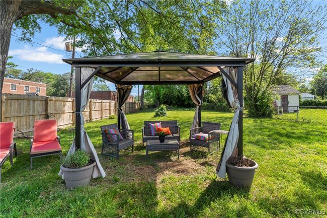 View of yard featuring an outdoor living space, a fenced backyard, and a gazebo | Image 35