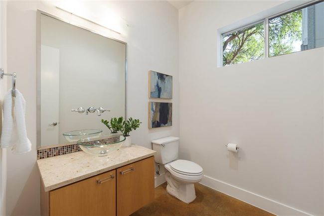 Half bathroom with vanity, toilet, baseboards, and concrete floors | Image 9