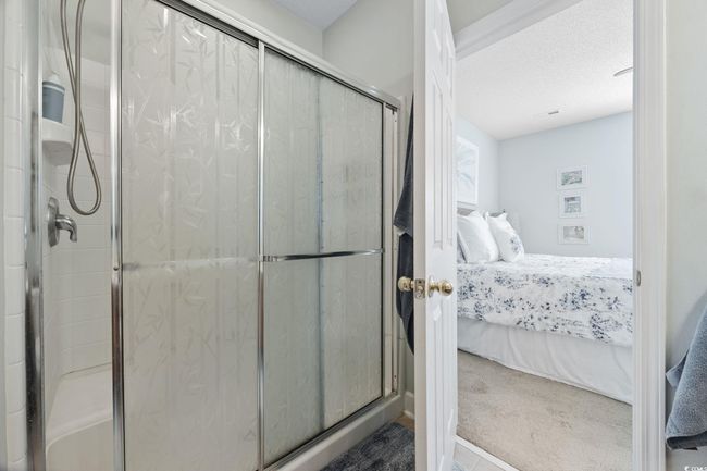 Full bathroom featuring ensuite bath, a stall shower, and a textured ceiling | Image 19
