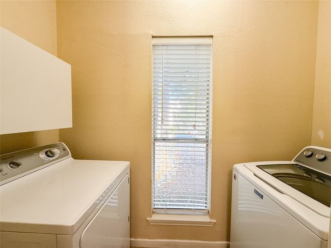 Washroom with a textured wall, healthy amount of natural light, and separate washer and dryer | Image 5