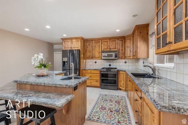 Kitchen featuring recessed lighting, a center island, appliances with stainless steel finishes, a sink, and backsplash | Image 20