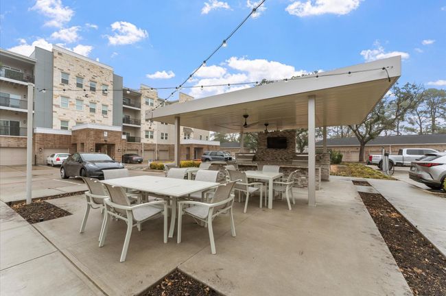 Resort-style outdoor kitchen and grilling station with covered seating, perfect for hosting barbecues and gatherings. | Image 24
