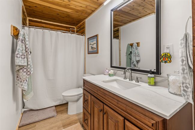 Bathroom featuring wood ceiling, vanity, wood finished floors, and curtained shower | Image 19