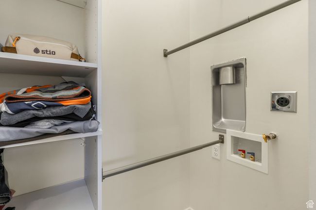 Separate from the main walk-in closet, the primary bathroom also features a dedicated laundry area with hookups, thoughtfully positioned behind a secure locking door. | Image 17