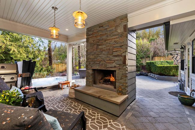 View of patio with an outdoor stone fireplace, a grill, and fence | Image 26