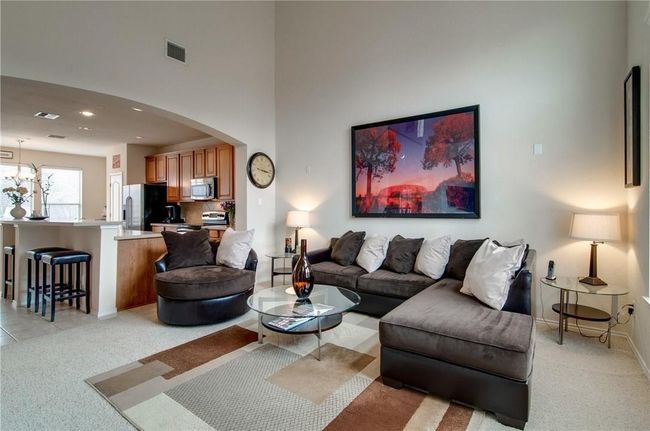 Carpeted living room featuring a towering ceiling | Image 20