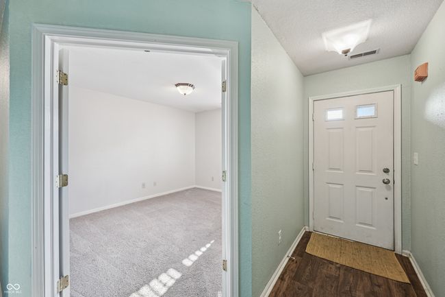 entryway featuring wood finished floors and a textured ceiling | Image 4