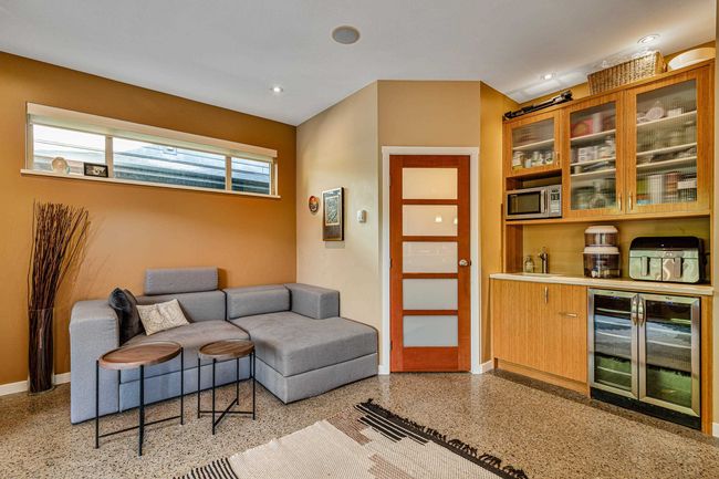 Living area with beverage cooler, dark speckled floor, and recessed lighting | Image 7
