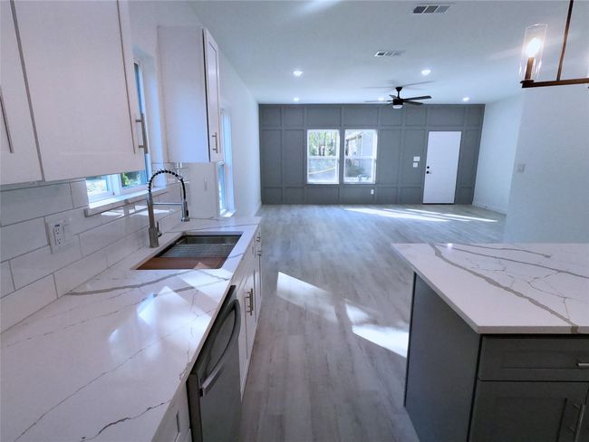 Kitchen with a healthy amount of sunlight, a sink, dishwashing machine, and light wood-type flooring | Image 9