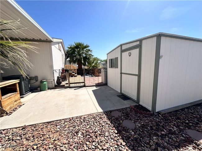 View of patio featuring a storage unit, fence, and an outbuilding | Image 4