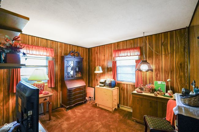 home office featuring dark carpet and wooden walls | Image 23