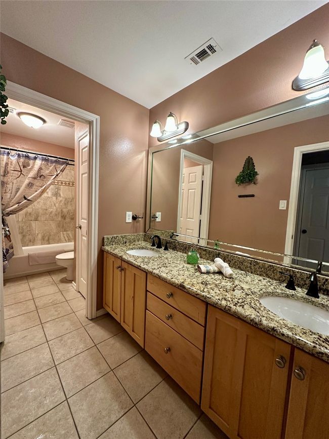 Bathroom with a sink, double vanity, visible vents, and tile patterned flooring | Image 19