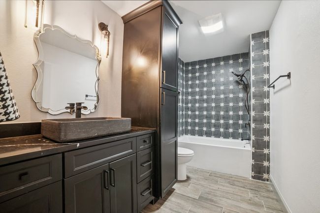 Full bathroom featuring a decorative sink and shower/bath combination | Image 26