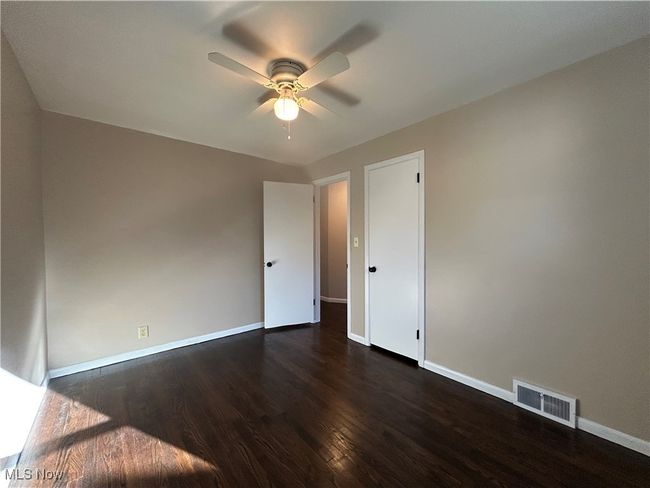 Bedroom featuring dark wood floors and a ceiling fan. | Image 23