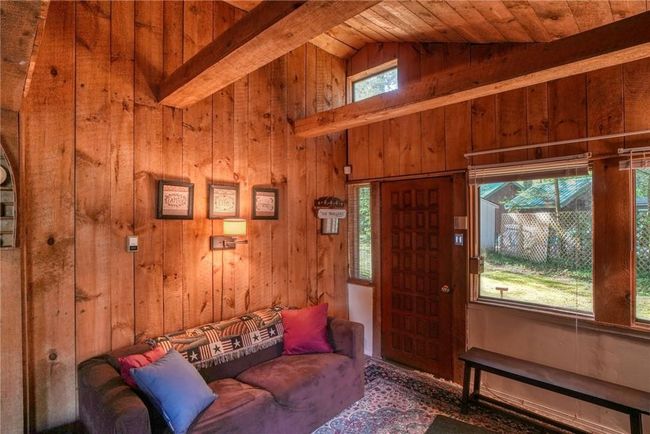 Living room with wood ceiling, vaulted ceiling with beams, and wood walls | Image 6