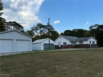 View of yard featuring a garage and an outbuilding | Image 3