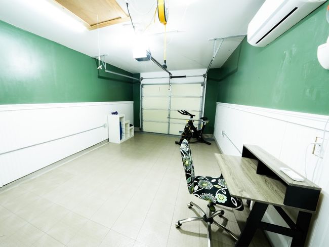Garage with a wainscoted wall, a garage door opener, and a wall mounted air conditioner | Image 23