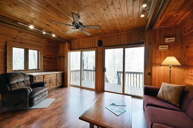 The living space has double sliding glass doors and a ceiling fan. | Image 71