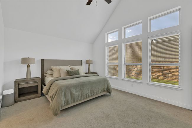 Bedroom featuring high vaulted ceiling, carpet flooring, baseboards, and ceiling fan | Image 25
