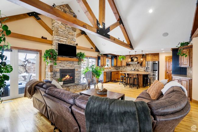 Living area featuring light wood-style floors, a stone fireplace, and a healthy amount of sunlight | Image 7