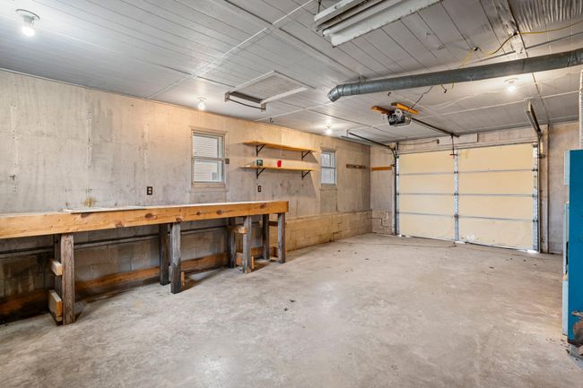 The attached one-stall garage offers a built-in workspace and shelving for added functionality. | Image 16