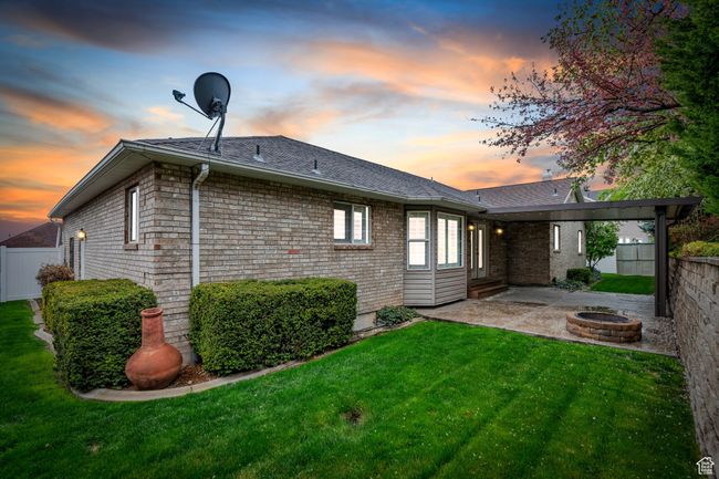 Back of property with a yard, a patio area, an outdoor fire pit, and fence | Image 48
