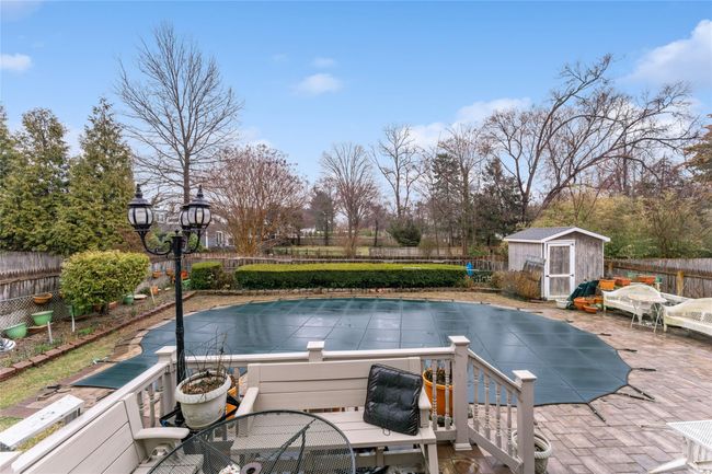 View of pool featuring an outbuilding, a fenced backyard, a storage unit, a fenced in pool, and outdoor dining area | Image 15