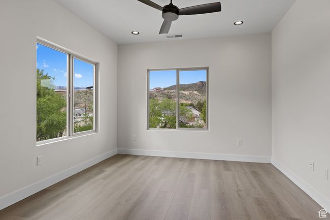 Unfurnished room with light wood finished floors, baseboards, visible vents, ceiling fan, and recessed lighting | Image 17