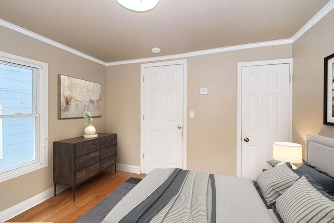 Bedroom with light wood-style floors and crown molding | Image 7