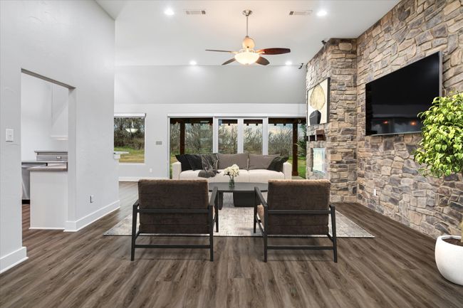 Living room with ceiling fan, dark wood-type flooring, and a high ceiling | Image 4