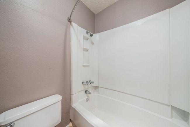 Bathroom with shower / tub combination and a textured ceiling | Image 26
