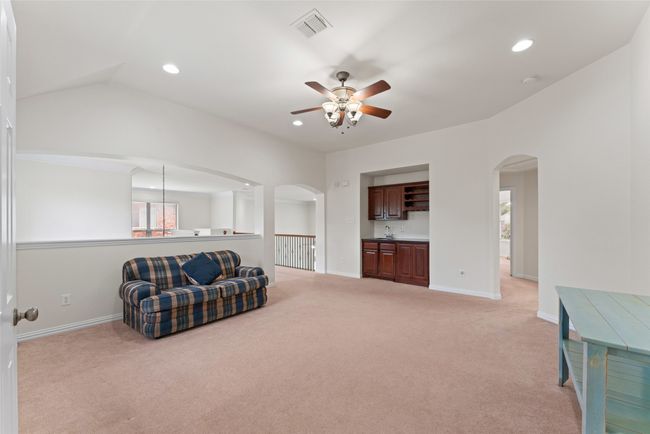 Living area with arched walkways, ceiling fan, light colored carpet, and recessed lighting | Image 23