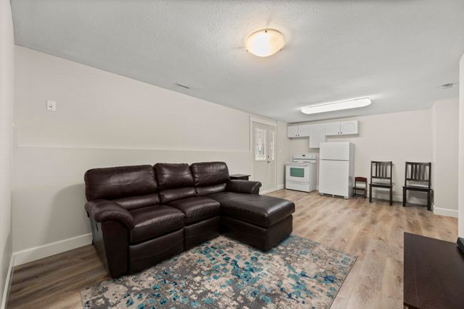 Living area featuring light wood-style floors, baseboards, and a textured ceiling | Image 27