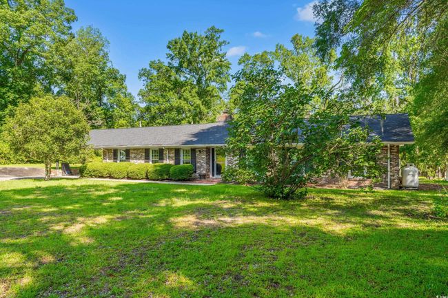Ranch-style house with a front yard, a chimney, and brick siding | Image 22