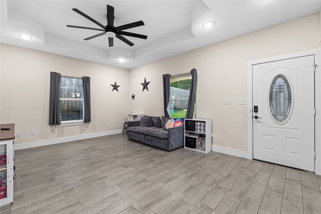 Foyer featuring a raised ceiling, a ceiling fan, light wood finished floors, and recessed lighting | Image 10