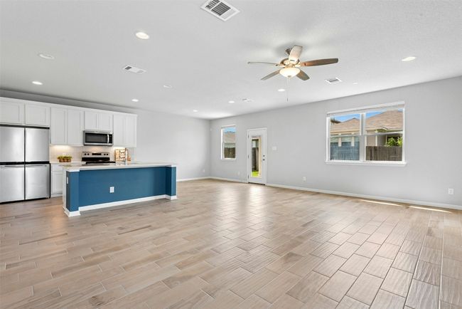 Kitchen featuring appliances with stainless steel finishes, open floor plan, ceiling fan, recessed lighting, and white cabinets | Image 6