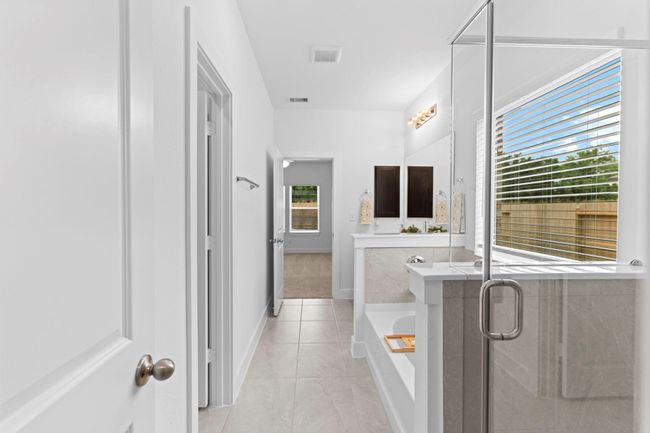 View from the primary closet through the bathroom shows off the open layout, connecting all the elements of your private retreat seamlessly. **Image Representative of Plan Only and May Vary as Built**. | Image 21