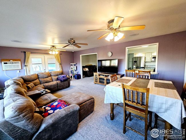 Great room from the NW corner showing the window into the kitchen and entrance from the living room | Image 10