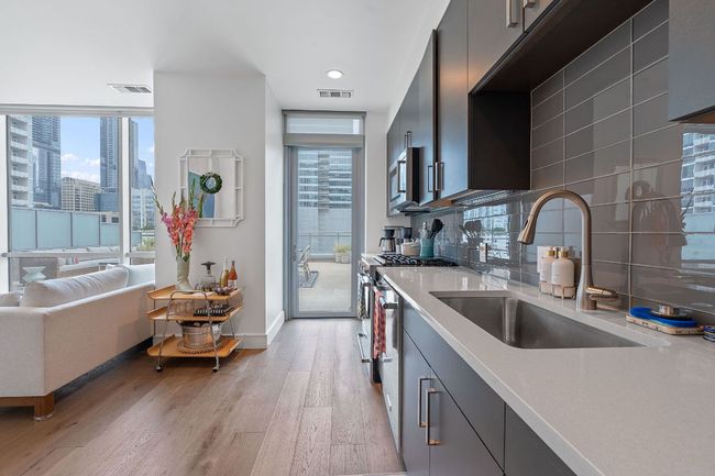 Kitchen with a sink, appliances with stainless steel finishes, light wood-style flooring, light countertops, and healthy amount of natural light | Image 7