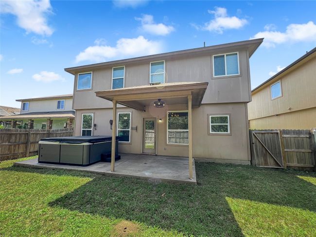 Rear view of property with a hot tub, a patio area, a fenced backyard, and a gate | Image 25