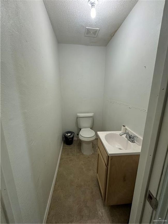 Bathroom with tile patterned floors, toilet, a textured ceiling, and vanity | Image 10