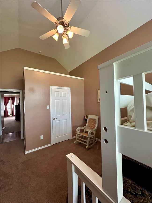 Hallway with baseboards, carpet floors, and lofted ceiling | Image 19