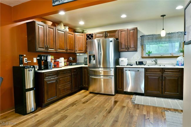 Kitchen featuring appliances with stainless steel finishes, light countertops, light wood-type flooring, decorative light fixtures, and recessed lighting | Image 9
