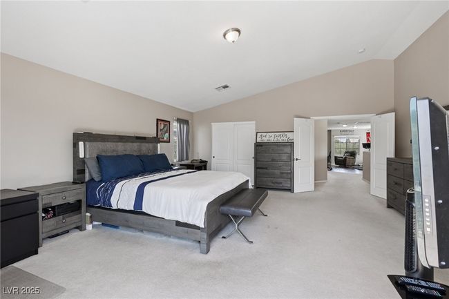 Bedroom with light colored carpet, vaulted ceiling, and a closet | Image 49