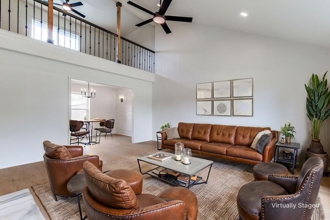 Living room with a ceiling fan, high vaulted ceiling, a chandelier, wood finished floors, and recessed lighting | Image 7