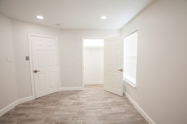 Unfurnished bedroom featuring light wood-type flooring, recessed lighting, a walk in closet, and a closet | Image 33