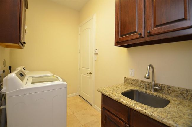Laundry downstairs with sink and washer and dryer included. | Image 38