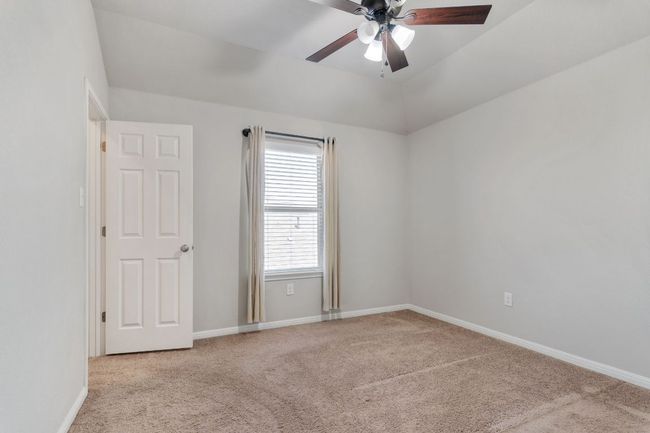 Unfurnished room with carpet, baseboards, vaulted ceiling, and ceiling fan | Image 29