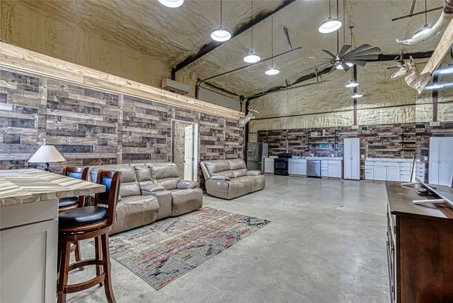Garage with stainless steel fridge, a ceiling fan, and freestanding refrigerator | Image 37