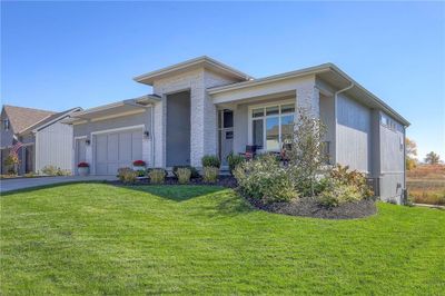 View of front of home with a garage and a front lawn | Image 1